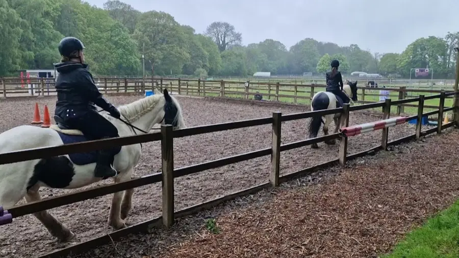 Two riders working in the outdoor arena at Kingsmead Equestrian Centre.